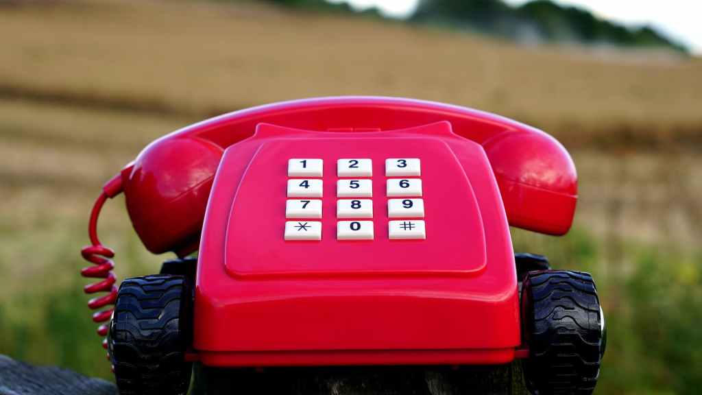 red rotary phone with black wheels