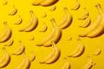 kilo banan, big and small bananas on a yellow background, artistically arranged 